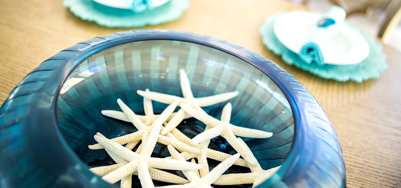 Sugar Beach Interiors, Miramar Beach, Florida. Decorative blue bowl filled with white starfish